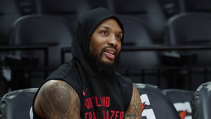 Nov 3, 2025; Portland, Oregon, USA;  Portland Trail Blazers guard Damian Lillard (0) watches teammates warm up before a game against the Los Angeles Lakers at Moda Center. Mandatory Credit: Troy Wayrynen-Imagn Images