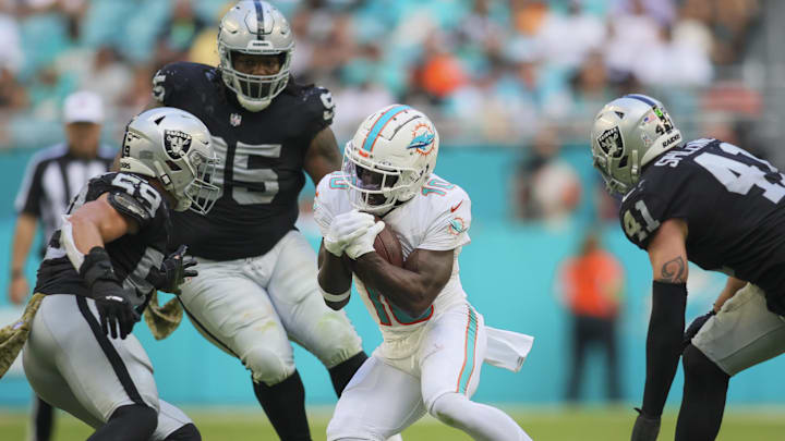 Nov 19, 2023; Miami Gardens, Florida, USA; Miami Dolphins wide receiver Tyreek Hill (10) runs with the football against Las Vegas Raiders linebacker Luke Masterson (59) during the third quarter at Hard Rock Stadium. Mandatory Credit: Sam Navarro-Imagn Images