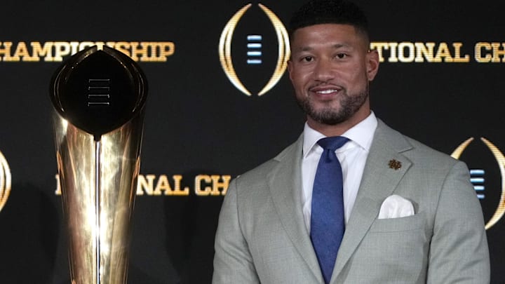 Jan 19, 2025; Atlanta, GA, USA; Ohio State Buckeyes head coach Ryan Day (left) and Notre Dame Fighting Irish head coach Marcus Freeman pose with the College Football Playoff National Championship trophy at press conference at The Westin Peachtree Plaza, Savannah Ballroom. 