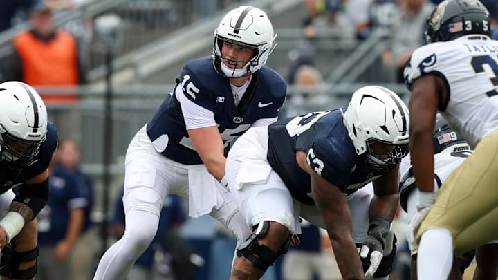 Penn State football quarterback Drew Allar lines up behind center Nick Dawkins 