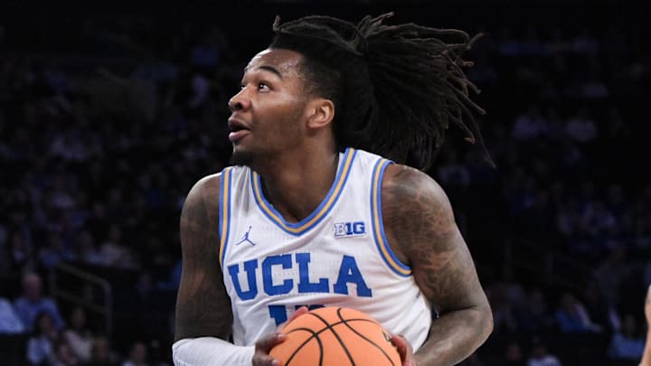 Dec 21, 2024; New York, NY, USA; UCLA Bruins guard Sebastian Mack (12) drives to the basket while being defended by North Carolina Tar Heels guard Ian Jackson (11) during the first half at Madison Square Garden. Mandatory Credit: John Jones-Imagn Images