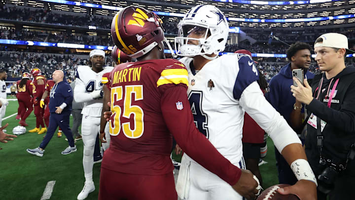 Washington Commanders DE Jacob Martin and Dallas Cowboys quarterback Dak Prescott hug after the game at AT&T Stadium