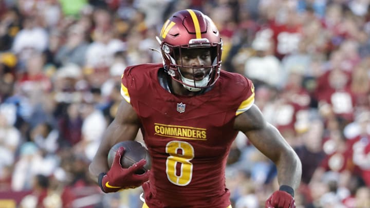 Oct 20, 2024; Landover, Maryland, USA; Washington Commanders running back Brian Robinson Jr. (8) carries the ball as Carolina Panthers cornerback Michael Jackson (2) and Panthers linebacker DJ Johnson (52) defends during the second half at Northwest Stadium. Mandatory Credit: Amber Searls-Imagn Images