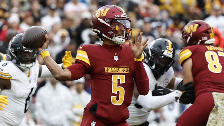 Nov 10, 2024; Landover, Maryland, USA; Washington Commanders quarterback Jayden Daniels (5) passes the ball as Pittsburgh Steelers linebacker Patrick Queen (6) defends during the first half at Northwest Stadium. Mandatory Credit: Geoff Burke-Imagn Images