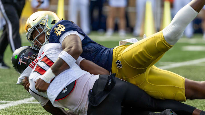 Oct 11, 2025; South Bend, Indiana, USA; Notre Dame Fighting Irish defensive lineman Boubacar Traore (5) sacks NC State Wolfpack quarterback CJ Bailey (11) during the first half at Notre Dame Stadium. Mandatory Credit: Michael Caterina-Imagn Images Oct 11, 2025; South Bend, Indiana, USA; Notre Dame Fighting Irish defensive lineman Boubacar Traore (5) sacks NC State Wolfpack quarterback CJ Bailey (11) during the first half at Notre Dame Stadium. Mandatory Credit: Michael Caterina-Imagn Images