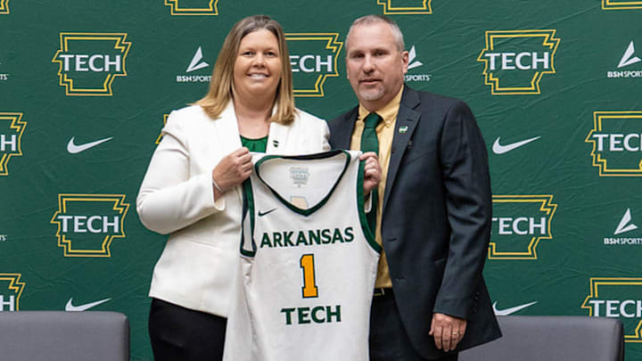 Arkansas Tech director of athletics Abby Davis, left, presents new head women's basketball coach Daryl Fimple with a jersey during a press conference on April 1. 
