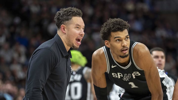 Dec 29, 2024; Minneapolis, Minnesota, USA; San Antonio Spurs interim head coach Mitch Johnson talks with center Victor Wembanyama (1) and guard Tre Jones (33) during a free throw against the Minnesota Timberwolves in the second half at Target Center.