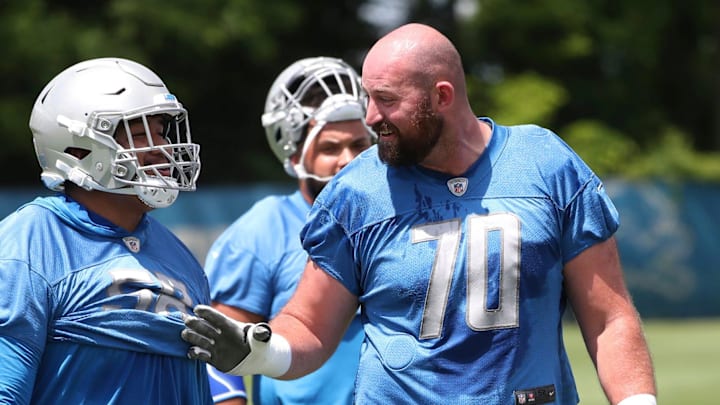 Lions offensive linemen Penei Sewell, left, and Dan Skipper talk during practice at minicamp 