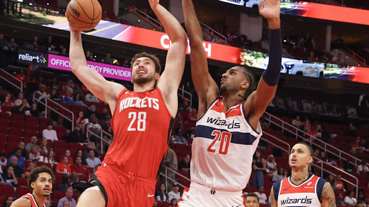 Nov 11, 2024; Houston, Texas, USA;  Houston Rockets center Alperen Sengun (28) scores against Washington Wizards forward Alexandre Sarr (20) in the first quarter at Toyota Center. Mandatory Credit: Thomas Shea-Imagn Images