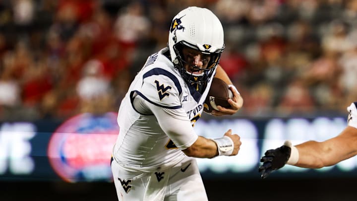 Oct 26, 2024; Tucson, Arizona, USA; West Virginia Mountaineers quarterback Nicco Marchiol (8) runs with the ball and gets tripped by Arizona Wildcats defender during the third quarter Arizona Stadium. Mandatory Credit: Aryanna Frank-Imagn Images