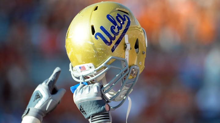 Sept 25, 2010; Austin, TX, USA; A member of the UCLA Bruins holds up his helmet to acknowledge their fans against the Texas Longhorns during the fourth quarter at Texas Memorial Stadium. UCLA beat Texas 34-12. Mandatory Credit: Brendan Maloney-Imagn Images