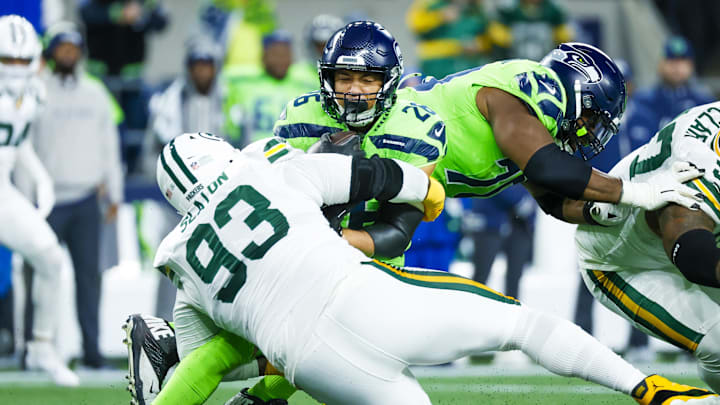 Dec 15, 2024; Seattle, Washington, USA; Green Bay Packers defensive tackle T.J. Slaton (93) tackles Seattle Seahawks running back Zach Charbonnet (26) for a loss during the first quarter at Lumen Field. Mandatory Credit: Joe Nicholson-Imagn Images