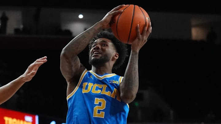 Mar 7, 2026; Los Angeles, California, USA; UCLA Bruins guard Donovan Dent (2) shoots the ball against Southern California Trojans forward Jacob Cofie (6) first half at Galen Center. Mandatory Credit: Kirby Lee-Imagn Images