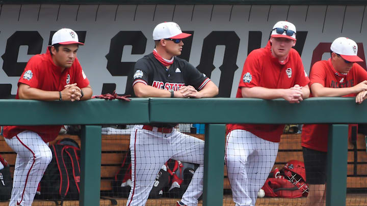 Jun 25, 2021; Omaha, Nebraska, USA; NC State Wolfpack pitcher Sam Highfill (17) and teammates wait out a delay due to players entering COVID protocol before the game against the Vanderbilt Commodores at TD Ameritrade Park. Mandatory Credit: Steven Branscombe-Imagn Images