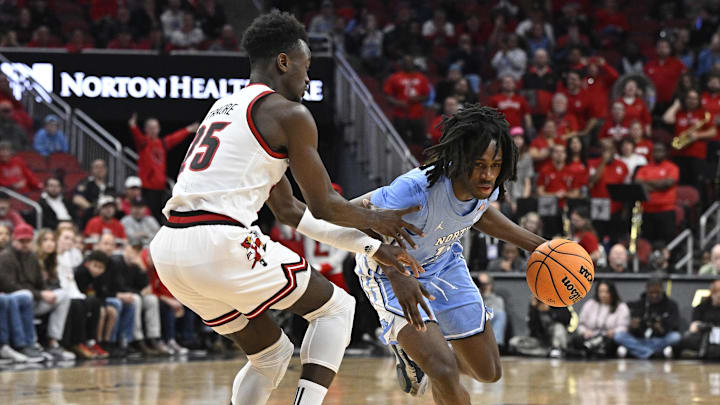 Jan 1, 2025; Louisville, Kentucky, USA;  North Carolina Tar Heels guard Ian Jackson (11) dribbles against Louisville Cardinals forward Aboubacar Traore (25) during the first half at KFC Yum! Center.