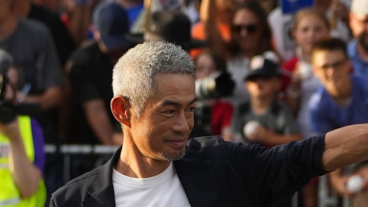 Hall of Fame Inductee Ichiro Suzuki waves to the crowd as he walks with his wife, Yumiko Fukushima at the National Baseball Hall of Fame during the Parade of Legends in Coopestown, NY. on July 26. 