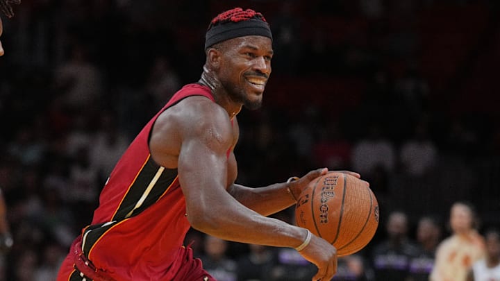 Nov 29, 2024; Miami, Florida, USA;  Miami Heat forward Jimmy Butler (22) dribbles past Toronto Raptors guard Ja'Kobe Walter (14) after being fouled during the second half in an NBA Cup game at Kaseya Center. Mandatory Credit: Jim Rassol-Imagn Images