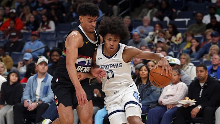 Nov 24, 2025; Memphis, Tennessee, USA; Memphis Grizzlies forward Jaylen Wells (0) drives to the basket as Denver Nuggets forward Spencer Jones (21) defends during the third quarter at FedExForum. Mandatory Credit: Petre Thomas-Imagn Images