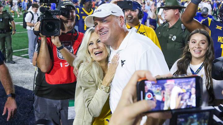 Sep 13, 2025; Morgantown, West Virginia, USA; West Virginia Mountaineers head coach Rich Rodriguez celebrates with his wife Rita after defeating the Pittsburgh Panthers at Milan Puskar Stadium. Mandatory Credit: Ben Queen-Imagn Images Sep 13, 2025; Morgantown, West Virginia, USA; West Virginia Mountaineers head coach Rich Rodriguez celebrates with his wife Rita after defeating the Pittsburgh Panthers at Milan Puskar Stadium. Mandatory Credit: Ben Queen-Imagn Images