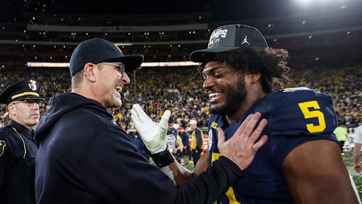 Former Michigan coach Jim Harbaugh celebrates with defensive end Josaiah Stewart Former Michigan coach Jim Harbaugh celebrates with defensive end Josaiah Stewart