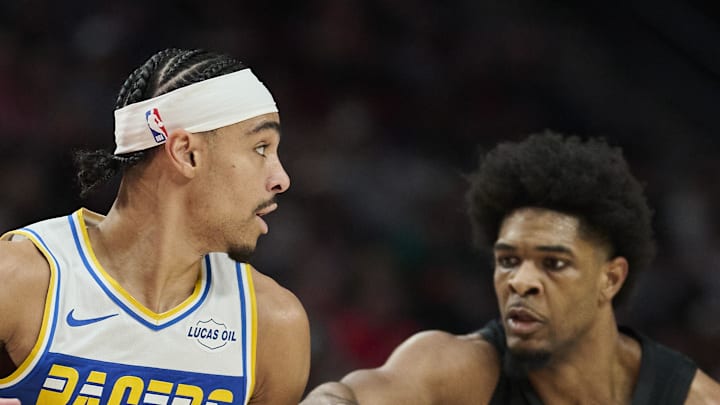 Indiana Pacers guard Andrew Nembhard dribbles the ball against Portland Trail Blazers guard Scoot Henderson.