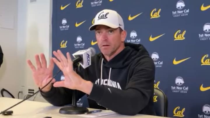 Justin Wilcox shows where Jaron-Keawe Sagapolutele should receive a shotgun snap