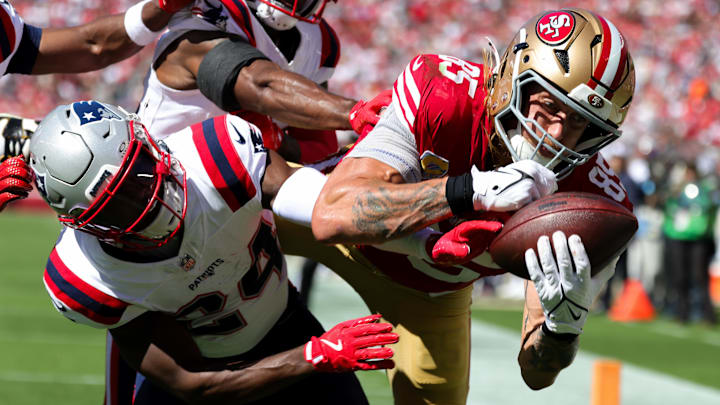 Sep 29, 2024; Santa Clara, California, USA; San Francisco 49ers tight end George Kittle (85) catches a touchdown against New England Patriots safety Dell Pettus (24) during the second quarter at Levi's Stadium. Mandatory Credit: Sergio Estrada-Imagn Images