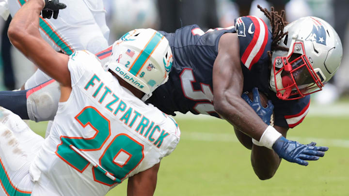 New England Patriots running back Rhamondre Stevenson (38) carries the football against Miami Dolphins safety Minkah Fitzpatrick (29) during the fourth quarter at Hard Rock Stadium.
