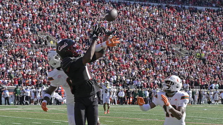 Oct 19, 2024; Louisville, Kentucky, USA;  Louisville Cardinals wide receiver Ja'Corey Brooks (1) attempts to catch a pass under the pressure of Miami Hurricanes defensive back Mishael Powell (0) and defensive back D'Yoni Hill (19) during the second half at L&N Federal Credit Union Stadium. Miami defeated Louisville 52-45. Mandatory Credit: Jamie Rhodes-Imagn Images