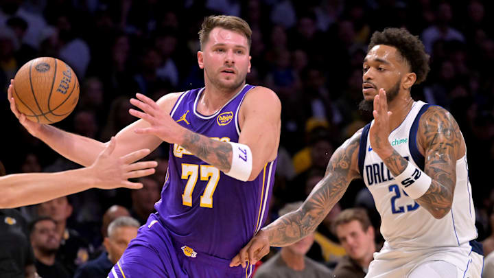 Nov 28, 2025; Los Angeles, California, USA;  Los Angeles Lakers guard Luka Doncic (77) is defended by Dallas Mavericks forward P.J. Washington (25) as he drives to the basket in the first half at Crypto.com Arena. Mandatory Credit: Jayne Kamin-Oncea-Imagn Images