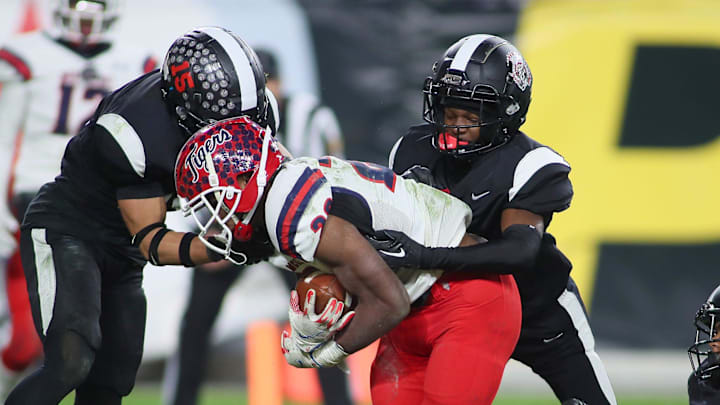 Aliquippa's QaLil Goode (14), Gavin Wilcox (13), and Arison Walker (15) attempt to hold back McKeesport's Kemon Spell (20) from scoring a touchdown during the second half of the WPIAL 4A Championship game Friday evening at Acrisure Stadium in Pittsburgh, PA. Aliquippa's QaLil Goode (14), Gavin Wilcox (13), and Arison Walker (15) attempt to hold back McKeesport's Kemon Spell (20) from scoring a touchdown during the second half of the WPIAL 4A Championship game Friday evening at Acrisure Stadium in Pittsburgh, PA.