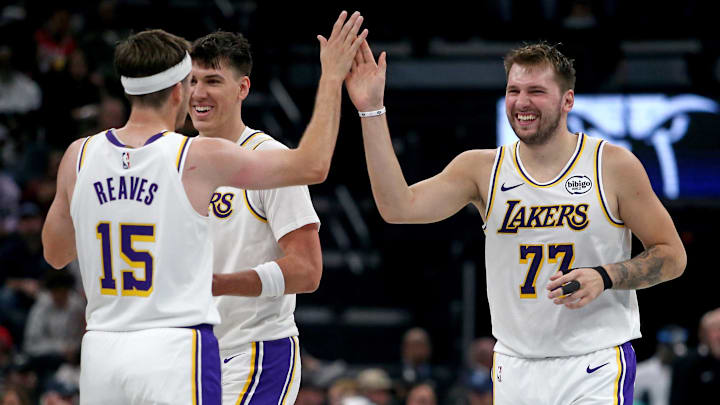 Oct 31, 2025; Memphis, Tennessee, USA; Los Angeles Lakers guard Luka Doncic (77) reacts with guard Austin Reaves (15) during a timeout during the second quarter against the Memphis Grizzlies at FedExForum. Mandatory Credit: Petre Thomas-Imagn Images