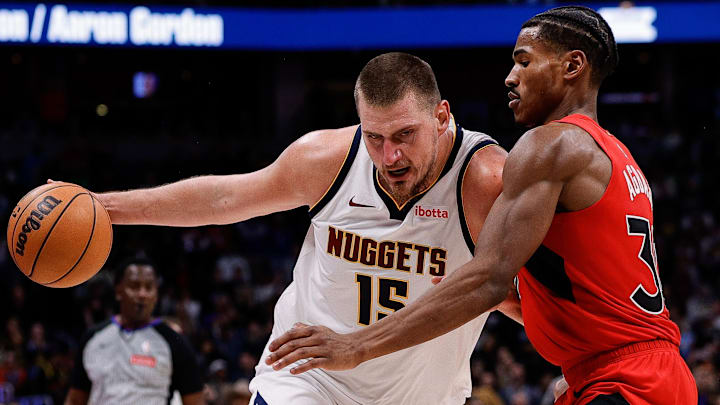 Nov 4, 2024; Denver, Colorado, USA; Denver Nuggets center Nikola Jokic (15) controls the ball as Toronto Raptors guard Ochai Agbaji (30) guards in the fourth quarter at Ball Arena.