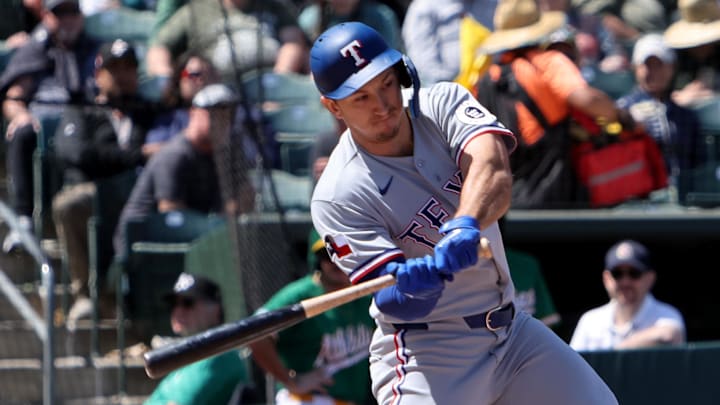 Texas Rangers center fielder Wyatt Langford swings his bat at a baseball. 
