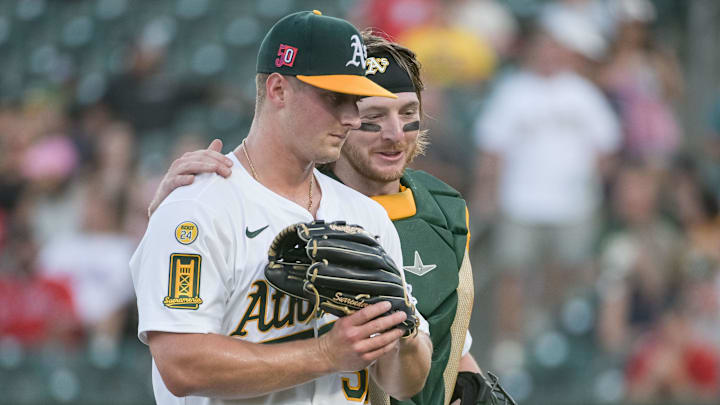 Aug 15, 2025; West Sacramento, California, USA; Athletics pitcher Jack Perkins (50) and catcher Willie MacIver (65) walk off the field during the first inning of the game against the Los Angeles Angels at Sutter Health Park. Mandatory Credit: Ed Szczepanski-Imagn Images