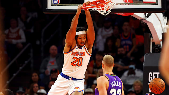 Nov 20, 2024; Phoenix, Arizona, USA; New York Knicks center Jericho Sims (20) dunks the ball against Phoenix Suns center Mason Plumlee (22) during the first quarter at Footprint Center. Mandatory Credit: Mark J. Rebilas-Imagn Images