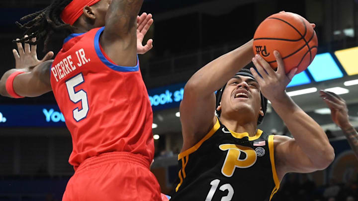 Feb 7, 2026; Pittsburgh, Pennsylvania, USA; Pittsburgh Panthers forward Roman Siulepa (13) drives the ball between SMU Mustangs guards Jaron Pierre Jr. (5) and Boopie Miller (2) during the first half  at Petersen Events Center. Mandatory Credit: Philip G. Pavely-Imagn Images
