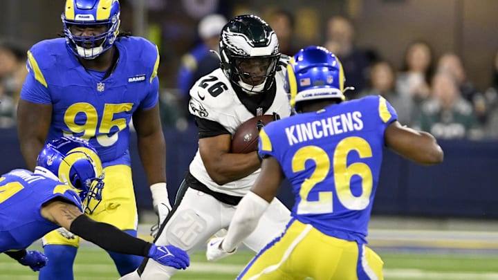 Nov 24, 2024; Inglewood, California, USA;  Philadelphia Eagles running back Saquon Barkley (26) runs against Los Angeles Rams cornerback Cobie Durant (left), and safety Kamren Kinchens (26) during the first half at SoFi Stadium. Mandatory Credit: Alex Gallardo-Imagn Images