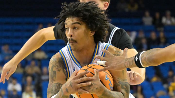 Dec 19, 2025; Los Angeles, California, USA; UCLA Bruins guard Skyy Clark (55) is defended by Cal Poly Mustangs forward Troy Plumtree (13) and guard Cayden Ward (14) as he drives to the basket during the first half at Pauley Pavilion presented by Wescom Financial. Mandatory Credit: Jayne Kamin-Oncea-Imagn Images