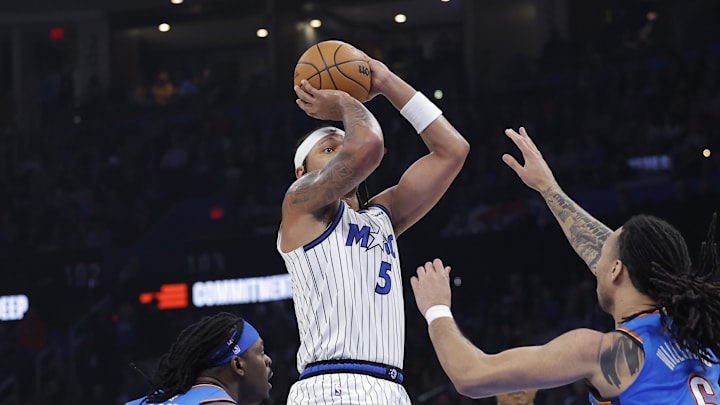 Feb 3, 2026; Oklahoma City, Oklahoma, USA; Orlando Magic forward Paolo Banchero (5) shoots from between Oklahoma City Thunder guard Luguentz Dort (5) and forward Jaylin Williams (6) during the second quarter at Paycom Center. Mandatory Credit: Alonzo Adams-Imagn Images