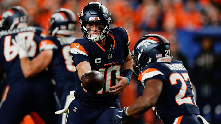 Sep 29, 2025; Denver, Colorado, USA; Denver Broncos quarterback Bo Nix (10) hands the ball off to Denver Broncos running back J.K. Dobbins (27) during the second quarter against the Cincinnati Bengals at Empower Field at Mile High. 