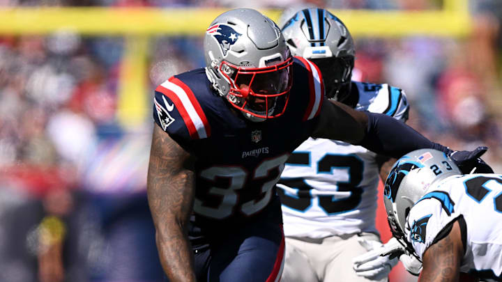 Sep 28, 2025; Foxborough, Massachusetts, USA; New England Patriots linebacker Anfernee Jennings (33) tackles Carolina Panthers running back Trevor Etienne (23) during the first half at Gillette Stadium. Mandatory Credit: Brian Fluharty-Imagn Images