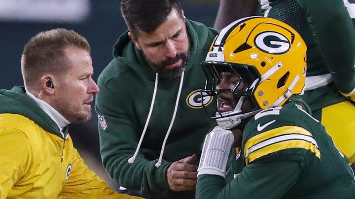Green Bay Packers quarterback Malik Willis (2) is checked out by trainers after tweaking his injured right shoulder.