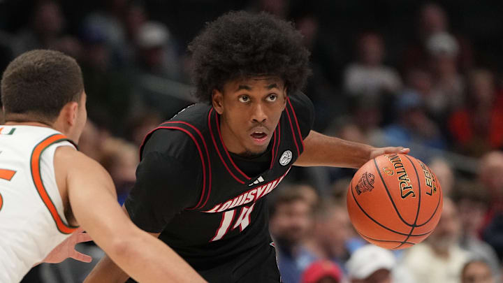 Mar 12, 2026; Charlotte, NC, USA; Louisville Cardinals guard Adrian Wooley (14) with the ball as Miami (FL) Hurricanes guard Dante Allen (35) defends in the first half at Spectrum Center. Mandatory Credit: Bob Donnan-Imagn Images