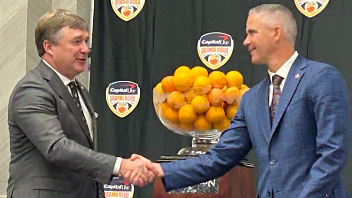 Georgia football coach Kirby Smart and Florida State coach Mike Norvell shake hands for the cameras after an Orange Bowl press conference on Dec. 29, 2023