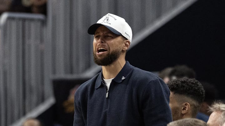 Mar 2, 2026; San Francisco, California, USA; Golden State Warriors guard Stephen Curry (in white baseball hat) cheers on his team against the Los Angeles Clippers during the second quarter at Chase Center. Mandatory Credit: D. Ross Cameron-Imagn Images