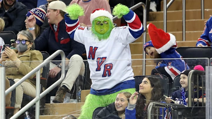Dec 8, 2024; New York, New York, USA; A New York Rangers fan dressed as the grinch cheers during the first period against the Seattle Kraken at Madison Square Garden. Mandatory Credit: Danny Wild-Imagn Images