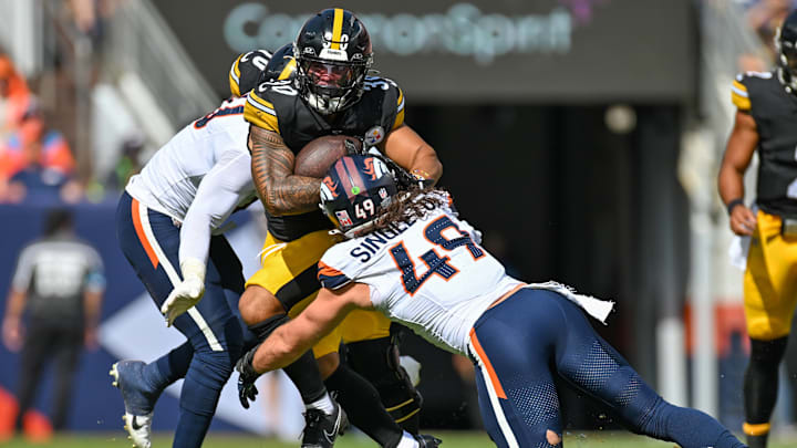 DENVER, CO - SEPTEMBER 15: Pittsburgh running back Jaylen Warren (30) runs the ball as Denver linebacker Alex Singleton (49) tries to pull him down during a game between the Denver Broncos and the Pittsburgh Steelers at Empower Field at Mile High in Denver, CO on September 15, 2024. 