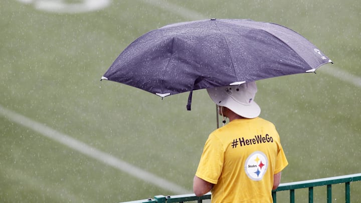 Jul 28, 2017; Latrobe, PA, USA; A staff member looks over the fields as rain delays the start of Pittsburgh Steelers training camp at Saint Vincent College. Mandatory Credit: Charles LeClaire-Imagn Images