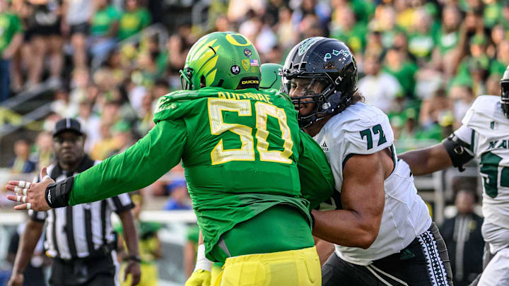 Sep 16, 2023; Eugene, Oregon, USA; Hawaii Warriors quarterback Brayden Schager (13) against pressure from Oregon Ducks defensive tackle Popo Aumavae (50) in the second quarter at Autzen Stadium.